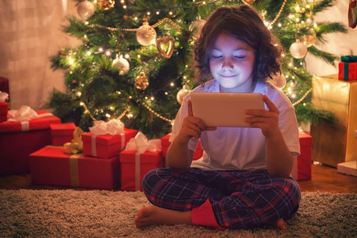 圣诞树下玩平板电脑的女孩