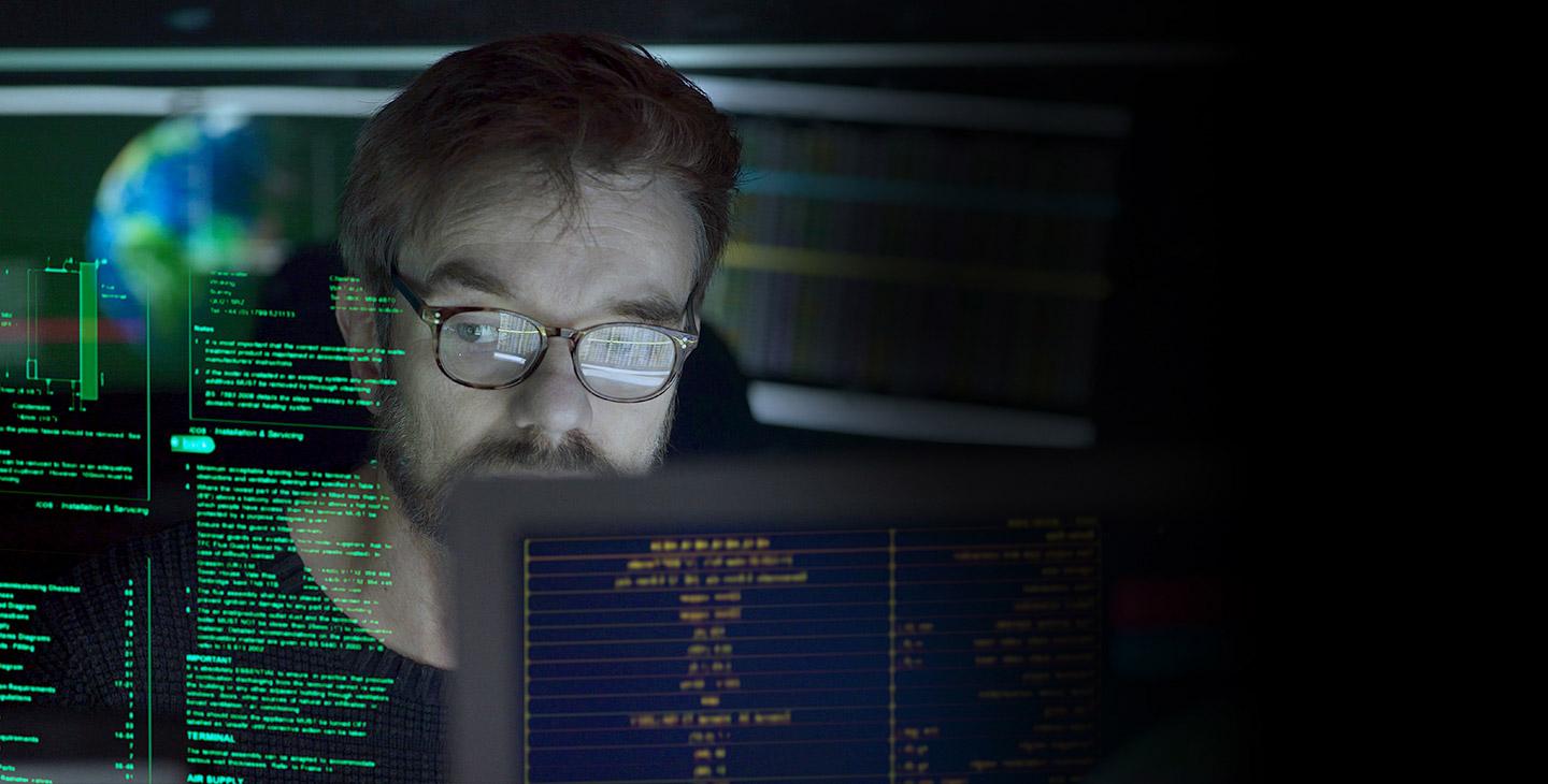 戴着眼镜看着电脑投影数据的男人