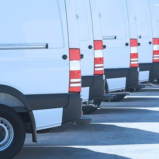 关闭-up image of the back tail lights of four white vans