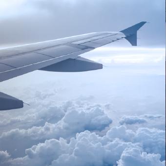 一架飞机的左翼在云层上飞行的特写