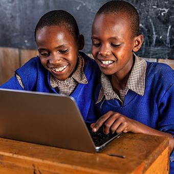 两个非洲男生对着笔记本电脑微笑