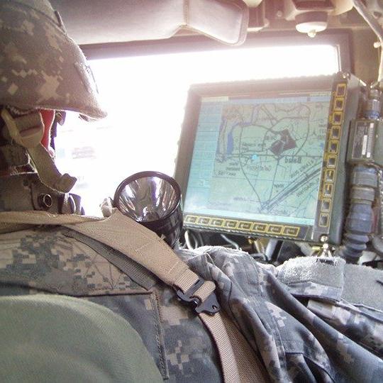 一辆车上的士兵在监视器上监测蓝军追踪项目的数据